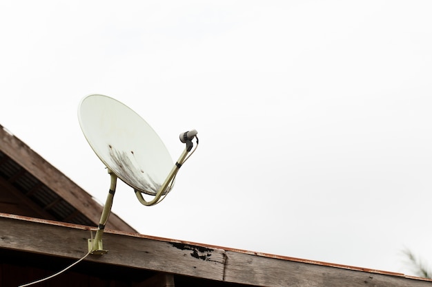 De oude Satellietschotels op houten huisdak