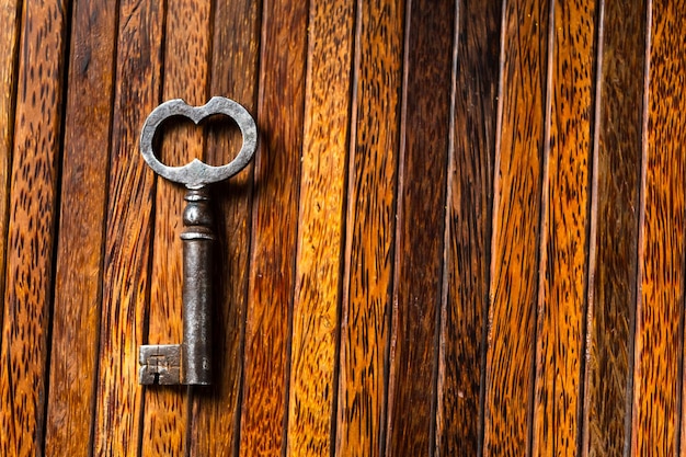 De oude sleutel ligt op een oude houten tafel natuurlijke texturen het concept van ontdekkingen geheimen antwoorden