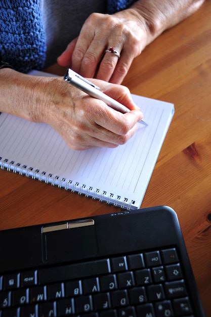 Foto de oude vrouw werkt met computer