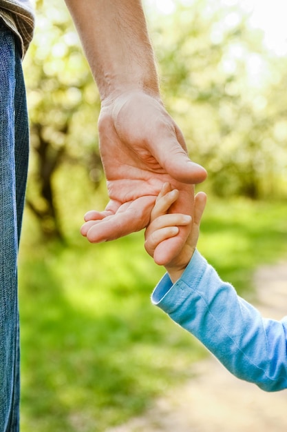 De ouder die de hand van het kind vasthoudt met een vrolijke achtergrond