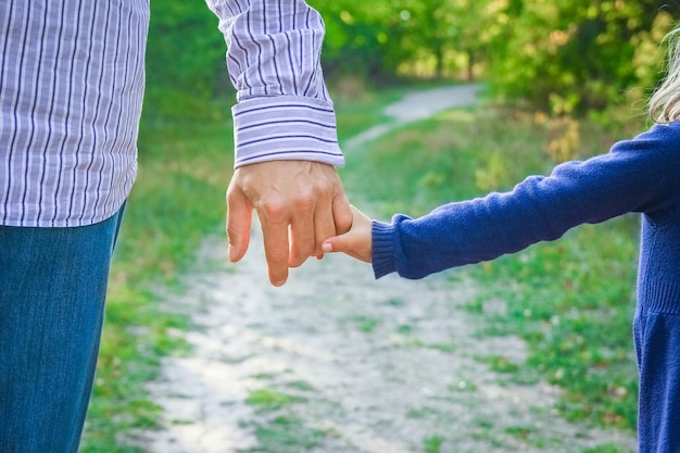 De ouder die de hand van het kind vasthoudt met een vrolijke achtergrond