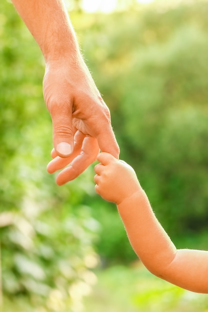 De ouder die de hand van het kind vasthoudt met een vrolijke achtergrond