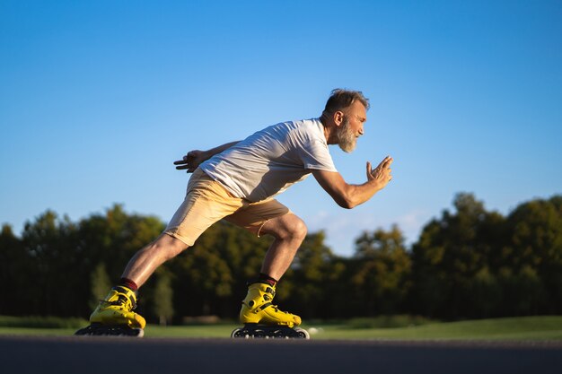 De oudere man rolschaatsen buiten