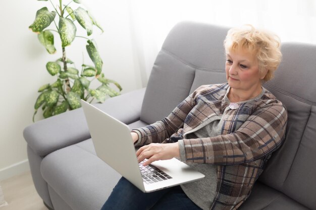 De oudere vrouw achter de computer