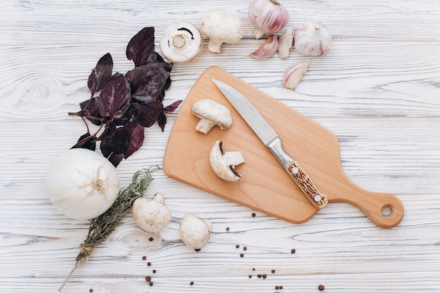 De paddestoelen met verschillende witte ingrediënten op houten lijst, hoogste mening en vlak leggen.