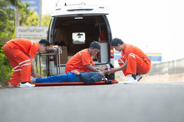 De paramedicus helpt een gewonde man in een noodsituatie op de weg