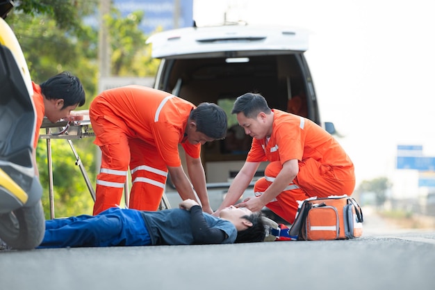 De paramedicus helpt een gewonde man in een noodsituatie op de weg