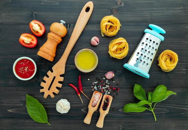 De pasta op zwarte houten achtergrond. Gele Italiaanse pasta met ingrediënten. Italiaans eten en menuconcept.