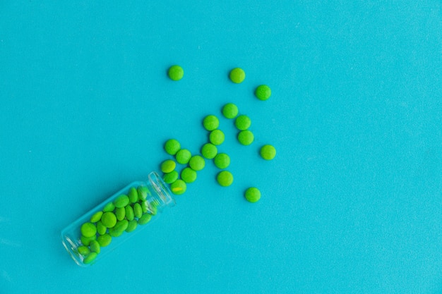 De pillen liggen verspreid op tafel. tabletten op de blauwe achtergrond. medicinale tabletten, capsules, pillen.