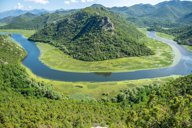 De pittoreske meanderende rivier stroomt door groene bergen