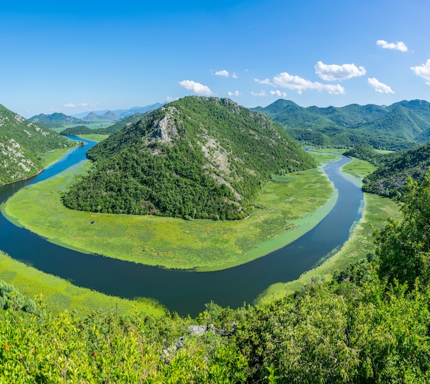 De pittoreske meanderende rivier stroomt tussen groene bergen