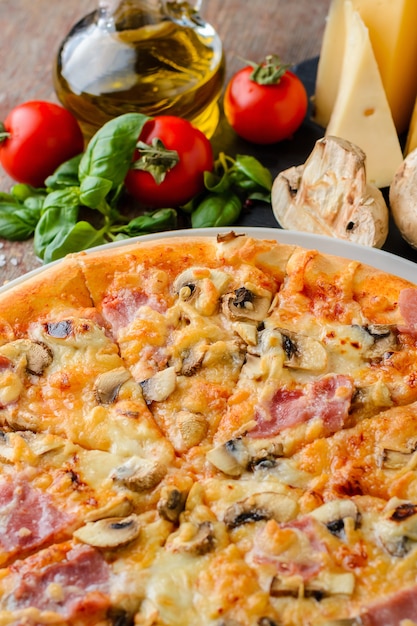 De pizza met ingrediënten op een houten achtergrond, sluit omhoog