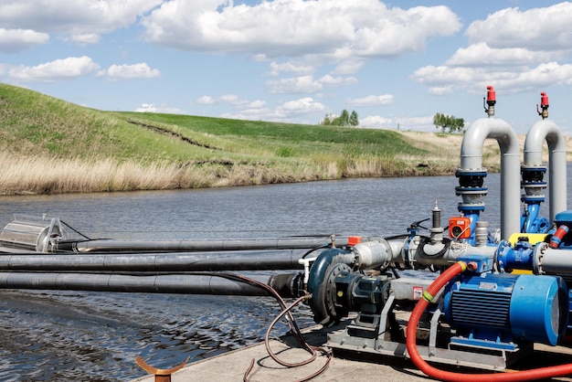 De pomp pompt water uit de rivier om landbouwgronden te irrigeren