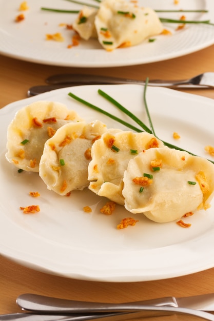 De Poolse bollen van de pierogischotel met vlees op witte plaat