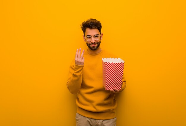 De popcorns die van de jonge mensenholding nummer drie tonen