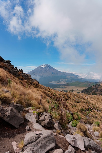 De Popocatepetl-vulkaan met een rotsachtige heuvel op de voorgrond