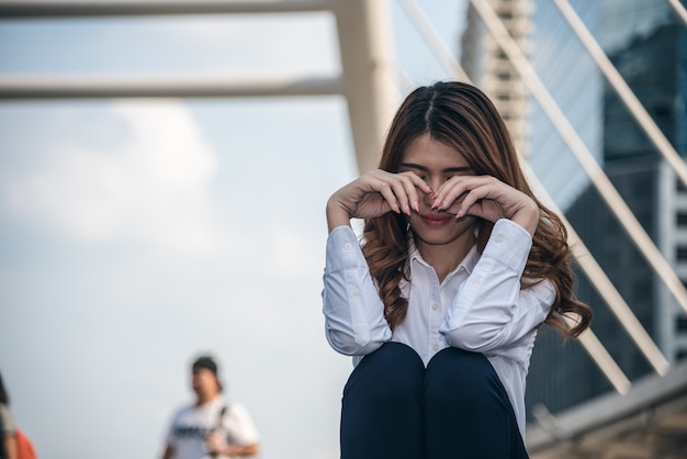 De portretten van mooie Aziatische vrouw schreeuwen en voelen droefheid van depressie in stedelijk.