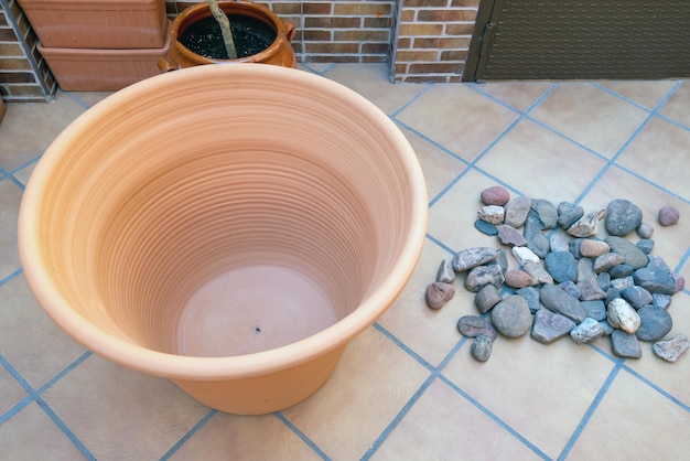 De pot en stenen voor een goede afwatering maken deel uit van de materialen die nodig zijn om een plant te planten.