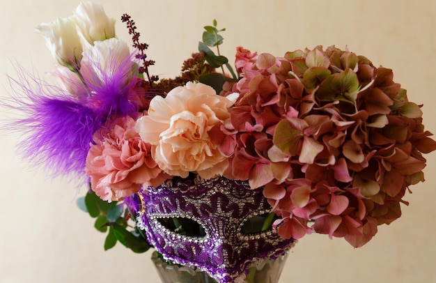 De prachtige bloemenbos met vast carnavalsmasker op effen achtergrond