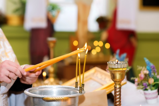De priester steekt kaarsen aan in de orthodoxe kerk
