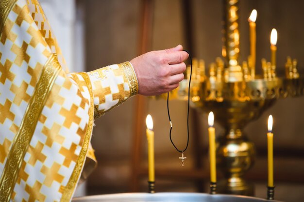 De priester verlicht het borstkruis