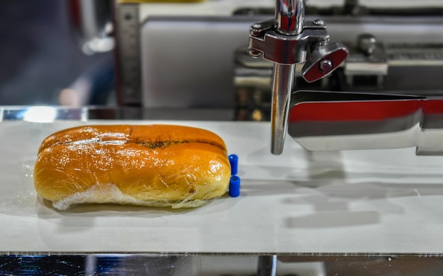 De productielijn van hamburgerbroodjes op machines voor transportbandapparatuur in de fabriek,