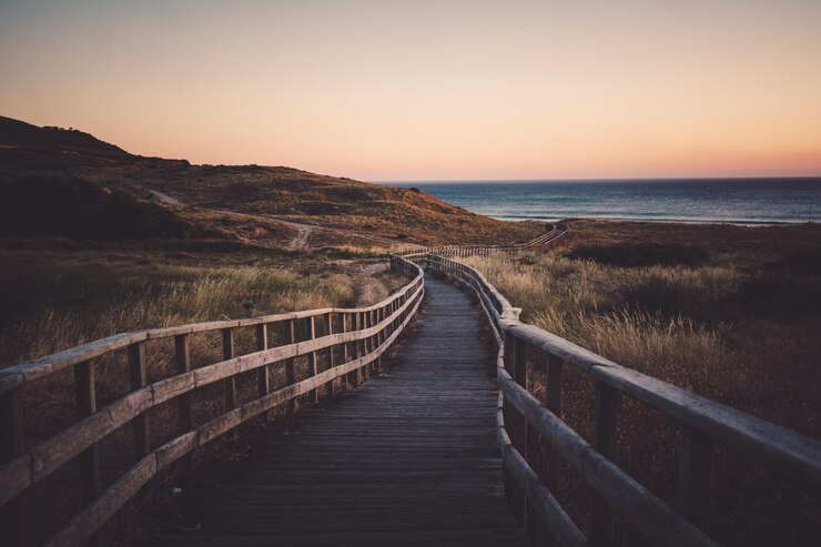 Foto de promenade die naar de zee leidt bij zonsondergang