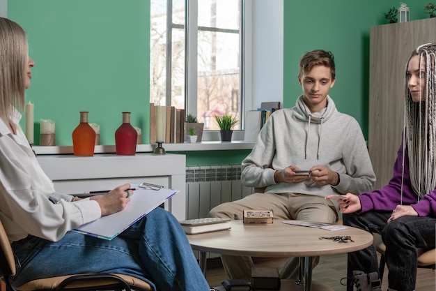 De psycholoog werkt met cliënten een jong getrouwd stel met behulp van MAC-kaarten