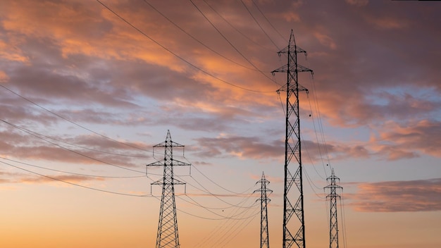 De pyloon van hoogspanningstorens op zonsondergang