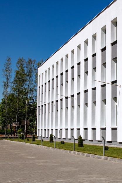 De ramen van het witte gebouw met drie verdiepingen