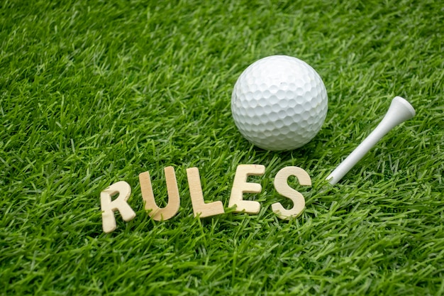 De regels van golfconcept met golfbal en het woord van Regels zijn op groen gras