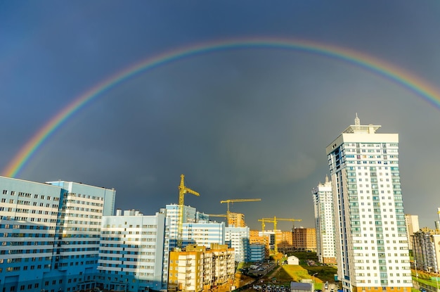 De regenboog strekt zich uit over de hoogbouw van de stad