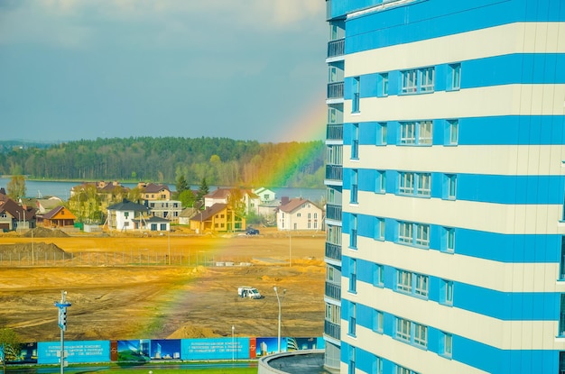 De regenboog strekt zich uit over de hoogbouw van de stad