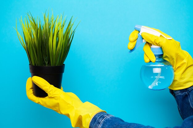 De reinigingsmachine in gele handschoenen sluit omhoog het water geven van de installatie