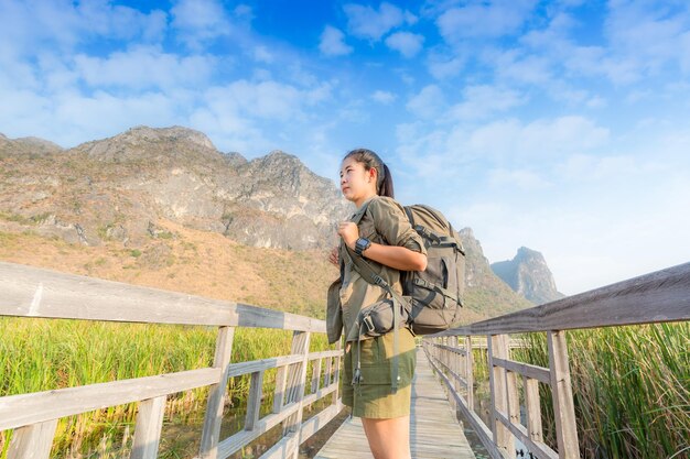 De reizigersvrouw die van de vrijheid zich met opgeheven wapens bevindt en van een mooie aard geniet en jonge toejuicht