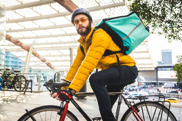 De renner van de voedselleveringsdienst die voedsel met fiets bezorgen