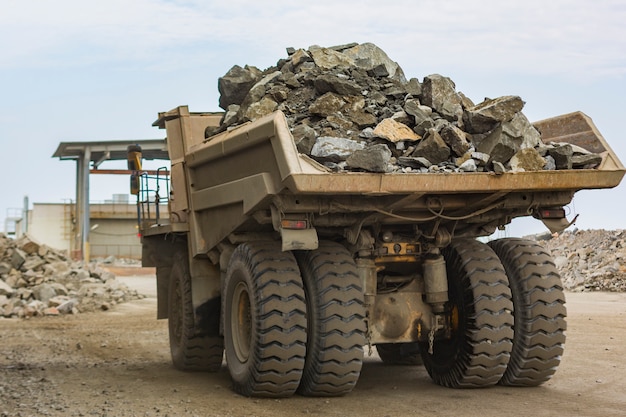 De reusachtige industriële volledig geladen mening van de stortplaatsvrachtwagen in steengroeve lage hoek