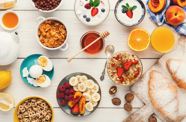 De rijke continentale achtergrond van het ontbijtmenu Heerlijke natuurlijke voeding voor smakelijke ochtendmaaltijden op houten tafel, traditioneel Europees buffet