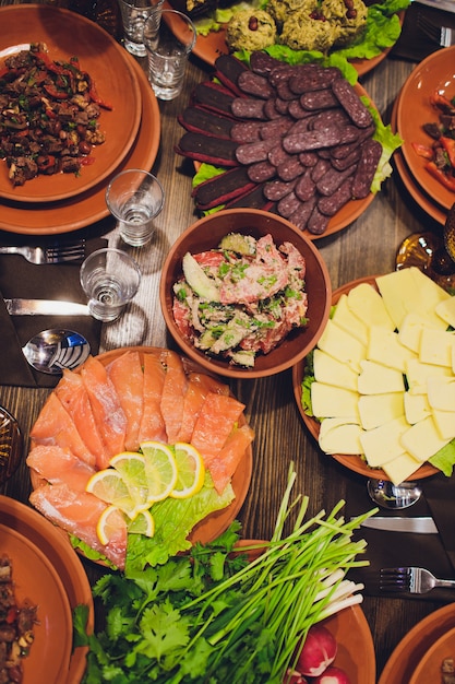 De rijkelijk gedekte tafelgerechten van de Georgische keuken, veel heerlijk eten, wijn, fruit en geroosterd vlees.