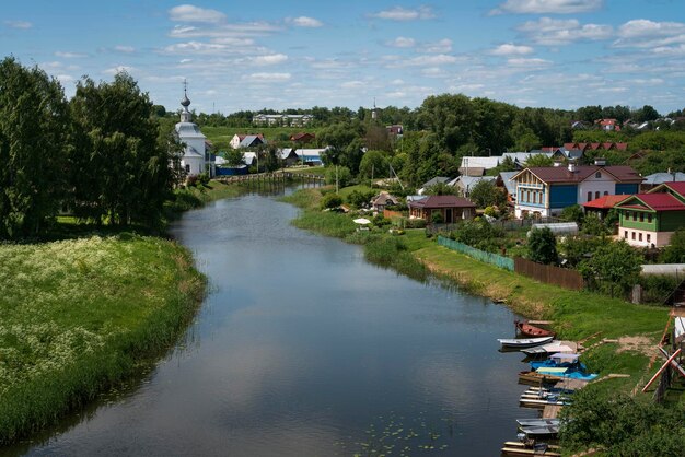 De rivier de Kamenka en de Kerk van de Epifanie op een zonnige zomerdag Suzdal Vladimir regio Rusland