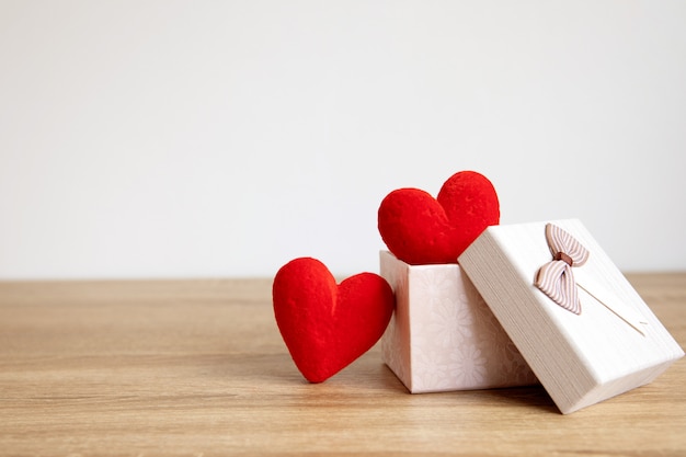 De rode hart vormen in geschenkverpakking op hout