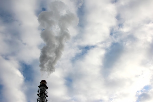 De rook uit de schoorsteen van een industriële onderneming in de lucht