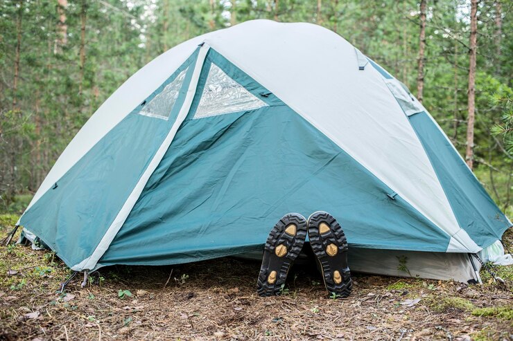 Foto de rubberen schoenen die buiten onder de tent liggen op de achtergrond groen hout