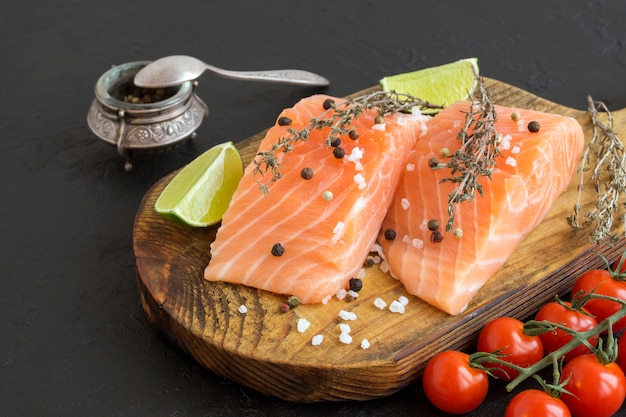 De ruwe die vissen van het zalmlapje vlees op het koken worden voorbereid. Bovenaanzicht op zwarte tafel.