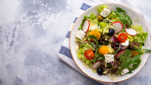 De salade verse groenten, sla, rucola en kaas van het gezonde en dieetconcept op een plaat. . Bovenaanzicht