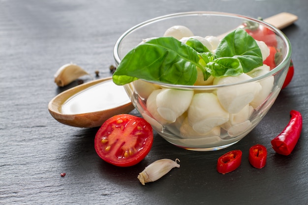 De saladeingrediënten van Caprese op donkere steenachtergrond