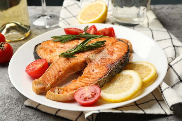 De samenstelling met smakelijke geroosterde zalm op grijze achtergrond, sluit omhoog