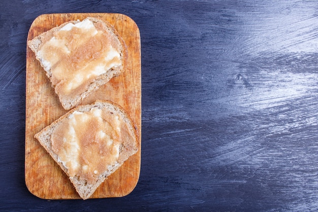 De sandwiches met pollock kuiten op een houten keuken schepen tegen zwarte achtergrond, hoogste mening in