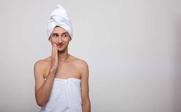 De schattige kerel na het douchen in een handdoek op zijn hoofd.