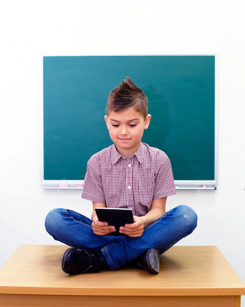 De schooljongen in lotusbloem stelt het bekijken tabletcomputer